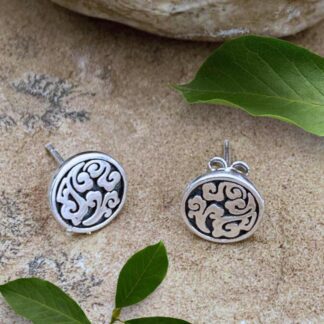 an image of Round Sterling Silver Disc Stud Earrings with dark oxidation in the background and a sterling silver swirling pattern