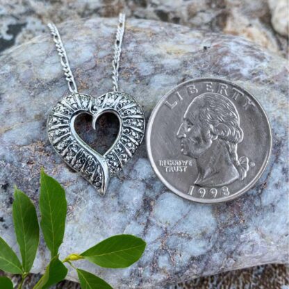 an image of a Sterling Silver Open Heart Pendant next to a quarter