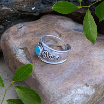 an image of a side view of an image of a sterling silver Bali Toe Ring with a round turquoise gemstone. Face height is 8.2 mm