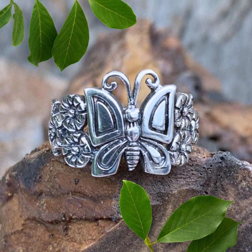an image of a sterling silver ring with a butterfly with flowers on each side