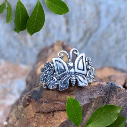 an image of a sterling silver ring with a butterfly with flowers on each side