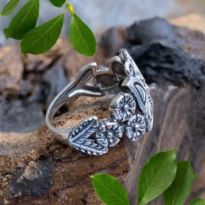 an image of a side vew of a sterling silver ring with a butterfly with flowers on each side