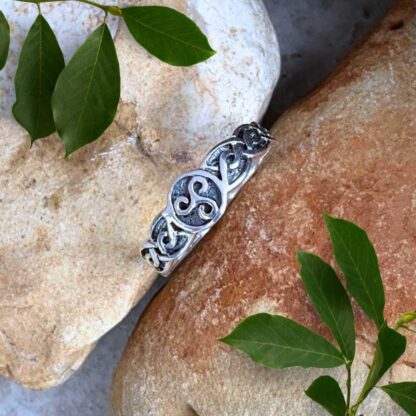 an image of a sterling silver ring with a Celtic Triskele symbol in a circle in the center and a Celtic knot design on each side