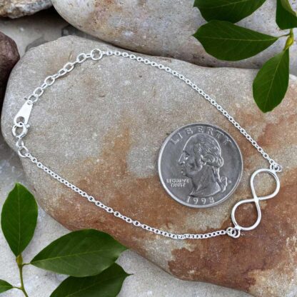 an image of a Sterling Silver Infinity Bracelet with one infinity symbol and next to a quarter