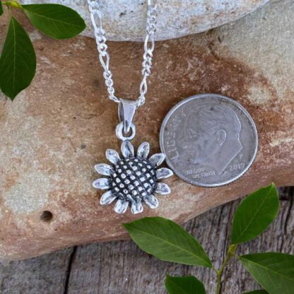 an image of a petite Sterling Silver Sunflower Pendant next to a dime. Pendant has a total drop of 21 mm