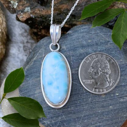 an image of an Oval Larimar and Sterling Silver Pendant next to a quarter