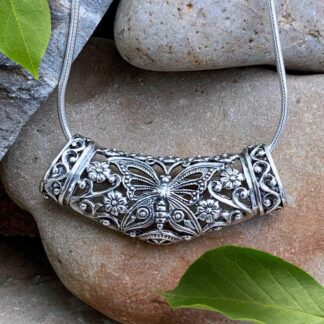 an image of an ornate filigree sterling silver pendant with a butterfly in the center and floral work. The chain runs through the center of the pendant