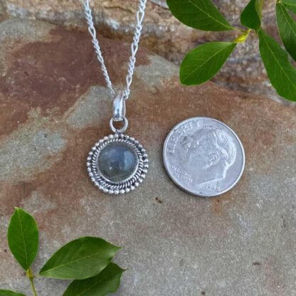 an image of a Dainty Round Labradorite and Sterling Silver Pendant next to a dime