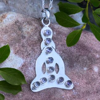 an image of a sterling silver silhouette figure in lotus post with faceted amethyst gemstones in a line down the center and across the bottom with ten amethysts total