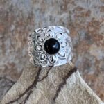 an image of a wide Sterling Silver Band style ring with a lotus design on top with a round black onyx stone in the center