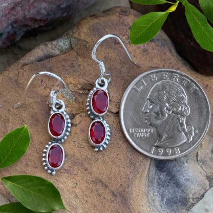 an image of a pair of Double Oval Ruby and Sterling Silver Dangle Earrings next to a quarter