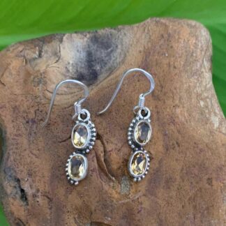 an image of a pair of dangle earrings with two oval citrine gemstones set in sterling silver