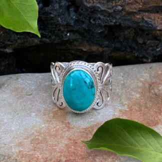 an image of an oval Turquoise ring in sterling silver with elegant filigree work on the sides