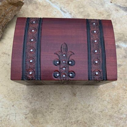 an image of a Pirate Trunk style Keepsake Box handcrafted of wood in a dark burgundy color with black trim. Made in Poland. Dimensions are 5.50 x 3.50 x 3.50 inches. This is an overhead view