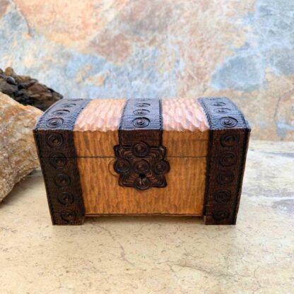 an image of a Handcrafted Wooden Locking Treasure Chest Made in Poland with a golden color wood and trimmed in a dark brown with swirl patterns. The chest is 5-1/8 in. x 3-1/8 in. x 3 inches