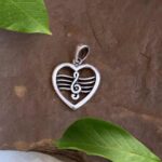 an image of a heart shaped sterling silver pendant with a treble clef on a staff on the inside of the heart