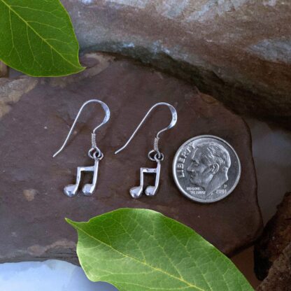 an image of a pair of Dainty Sterling Silver Music Note Dangle Earrings. Each earring is a pair of beamed eighth notes.