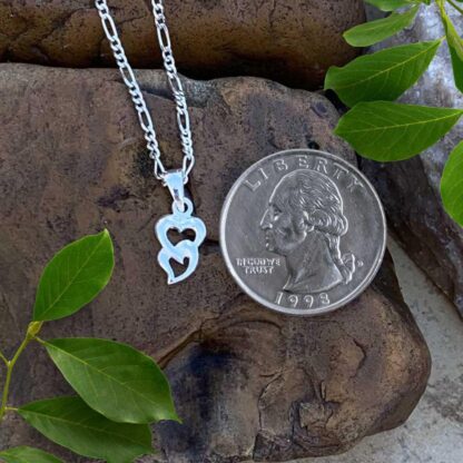 an image of a Petite Sterling Silver Interlocking Double Heart Pendant next to a quarter