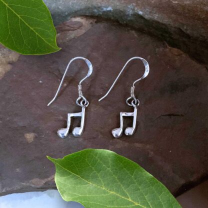 an image of a pair of Dainty Sterling Silver Music Note Dangle Earrings. Each earring is a pair of beamed eighth notes.