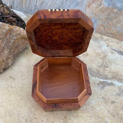 an image of an open inside view of an Octagon Shaped Moroccan Thuya and Lemon Wood Box. The top has beautiful burl wood and four sides have a striped inlay pattern of yellow lemon wood with lemon wood that has been dyed black. The dimensions are 4.5 x 4.5 x 2 inches.