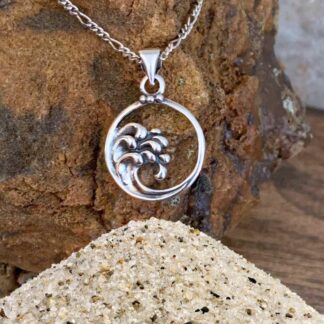 an image of a sterling silver round open pendant with ocean waves cresting on the left side of it and the face height of the pendant is .724 inches