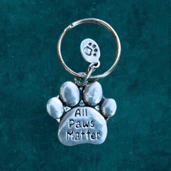 A pewter Keychain that is a paw that says All Paws Matter