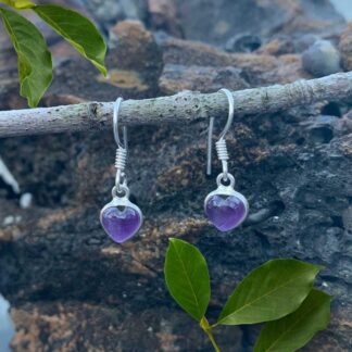 an image of a tiny carved amethyst cabachon heart earring in a simple serling silver setting with a slight dangle.