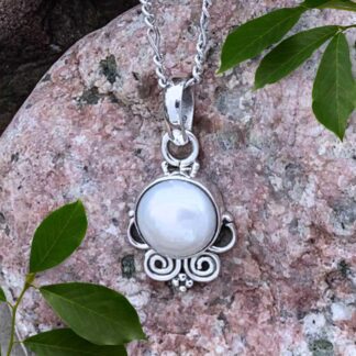 an image of a dainty round pearl set in sterling silver with a swirl pattern at the bottom.