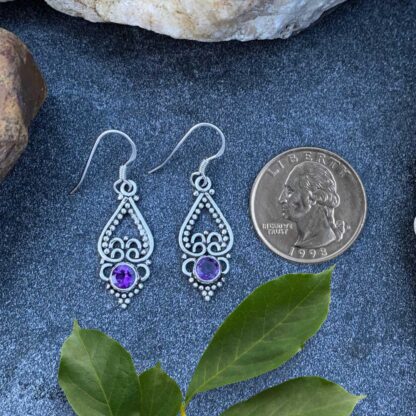 an image of a pair of sterling silver upside down open heart earrings with a faceted amethyst gemstone at the bottom