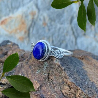 an image of an oval lapis lazuli gemstone ring with a sterling silver leaf on each side of the stone