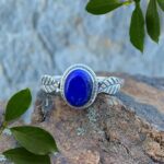 an image of an oval lapis lazuli gemstone ring with a sterling silver leaf on each side of the stone