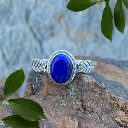 an image of an oval lapis lazuli gemstone ring with a sterling silver leaf on each side of the stone