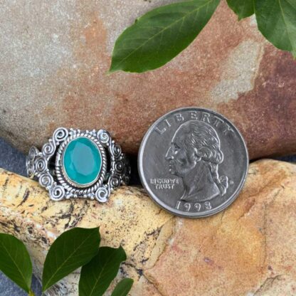 an image of an oval faceted aqua chalcedony gemstone set in sterling silver with a bohemian pattern of multi spirals.