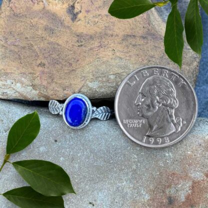 an image of an oval lapis lazuli gemstone ring with a sterling silver leaf on each side of the stone