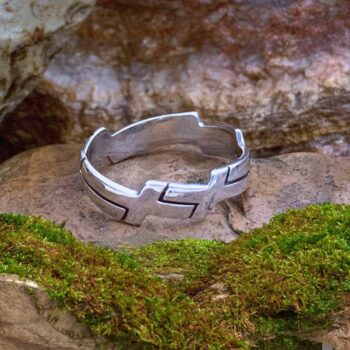 an image of a sterling silver band ring with interlocking crosses wrapping around the ring