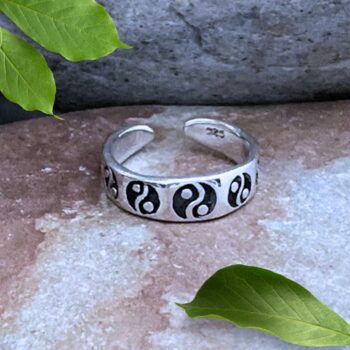 an image of a sterling silver toe ring with the yin yang symbol wrapping around it. Toe ring is adjustable