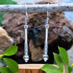 an image of a vertical pair of sterling stick style dangle earrings with a Bali design on the bottom section. Nice subtle boho look with medium dangle.