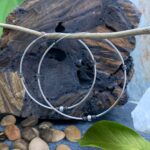 an image of a pair of very Large Sterling Silver Bali Continuous Hoop Earrings with a silver ball at bottom of each hoop
