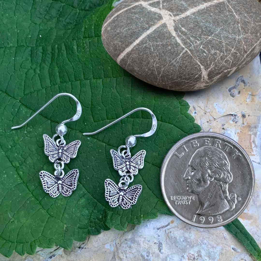 an image of a lightweight pair of Oxidized Sterling Silver Double Butterfly Dangle Earrings next to a quarter