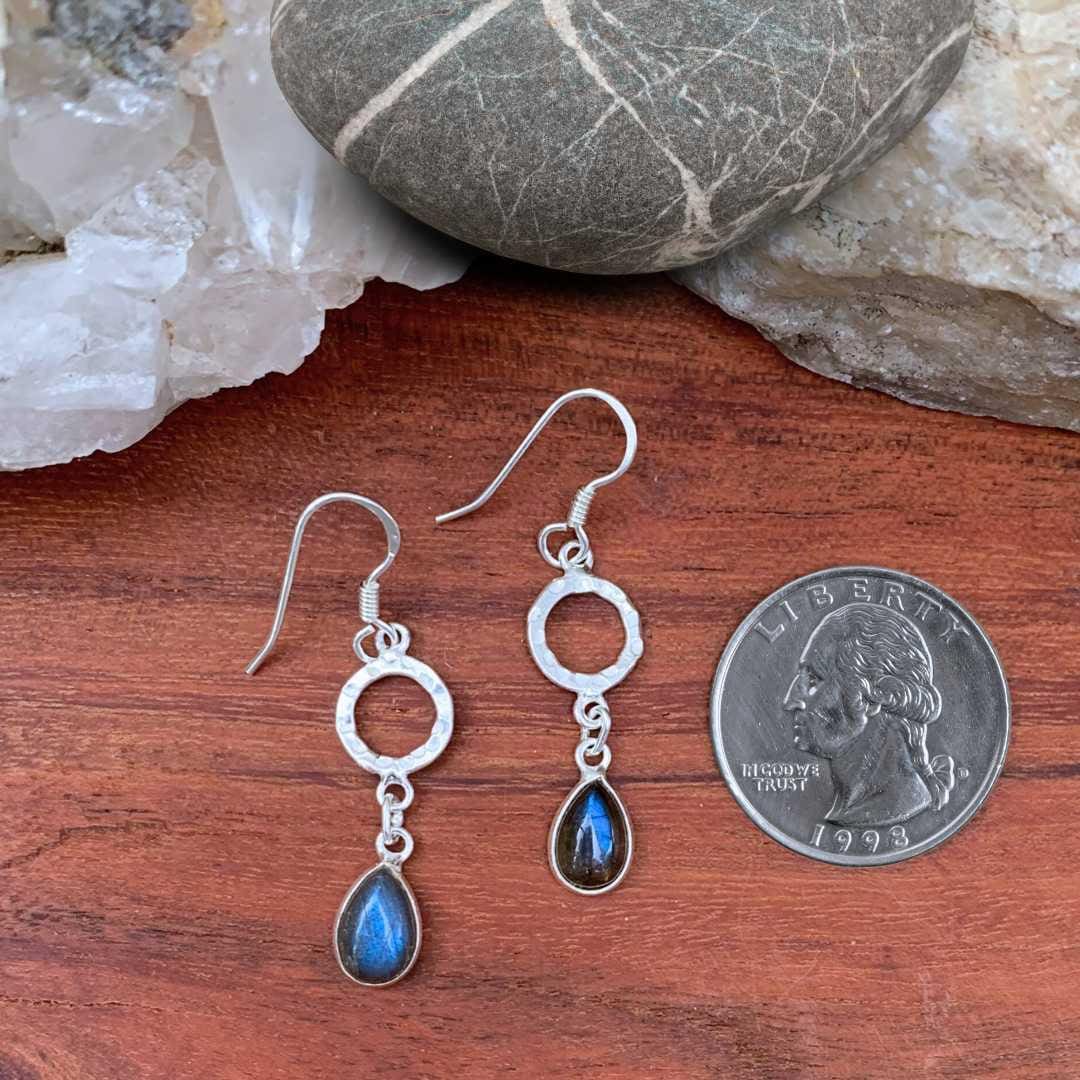 an image of a pair of Hammered Sterling Circle with Labradorite Teardrop Earrings next to a quarter
