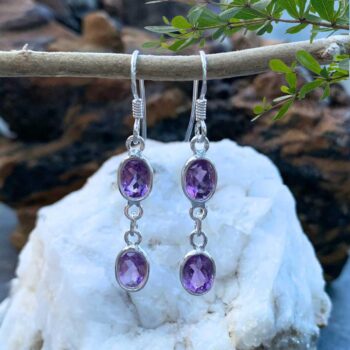 an image of a pair of Double Faceted Amethyst and Sterling Silver Earrings. Two oval faceted amethysts with a medium dangle