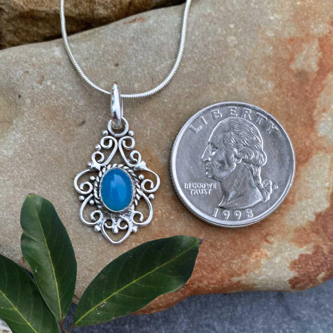 an image of a Filigree Sterling Silver and Blue Chalcedony Pendant next to a quarter