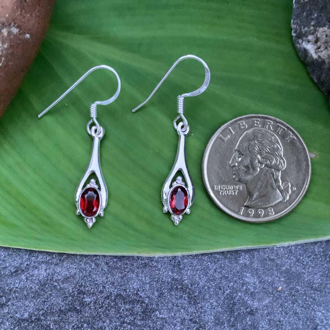 an image of a pair of Polished Sterling Silver and Oval Garnet Earrings next to a quarter