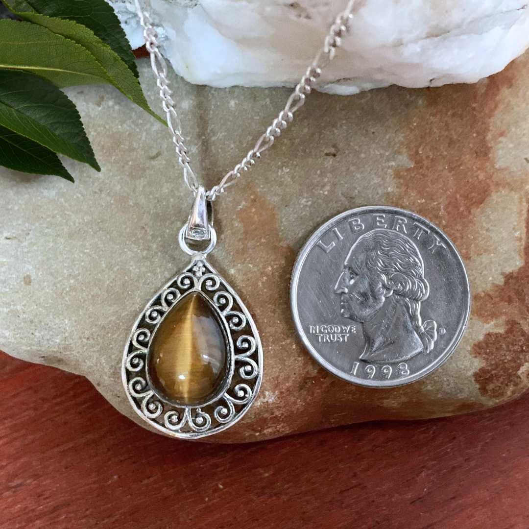 an image of a Teardrop Tiger's Eye Filigree Sterling Silver Pendant next to a quarter