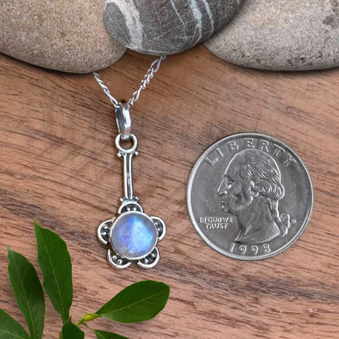 an image of a Flower Rainbow Moonstone and Sterling Silver Pendant next to a quarter