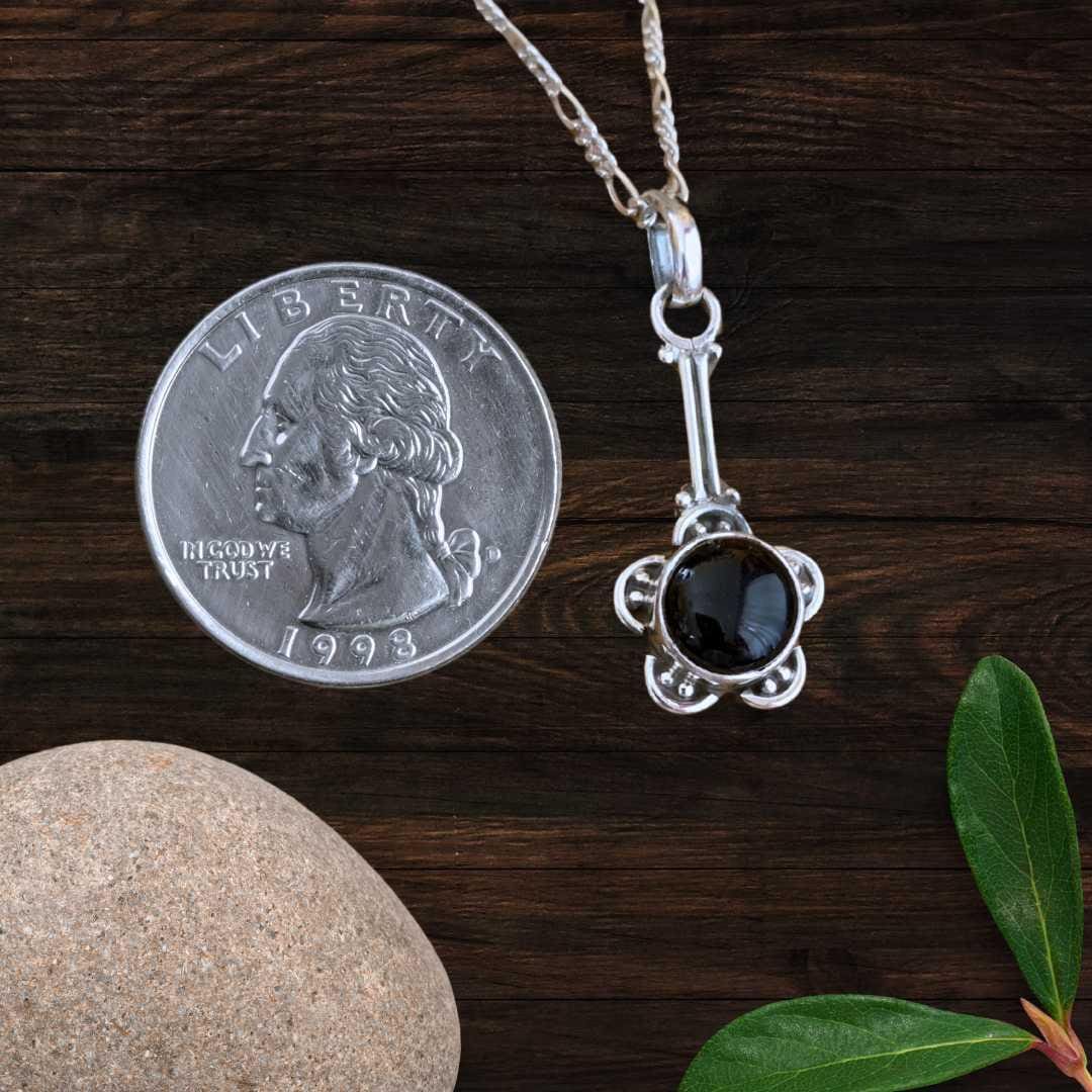 an image of a Flower Black Onyx and Sterling Silver Pendant next to a quarter