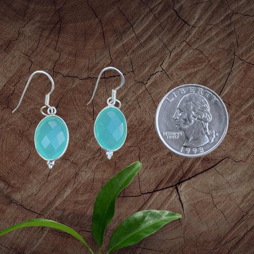 an image of a pair of Oval Faceted Aqua Chalcedony and Sterling Silver Earrings next to a quarter