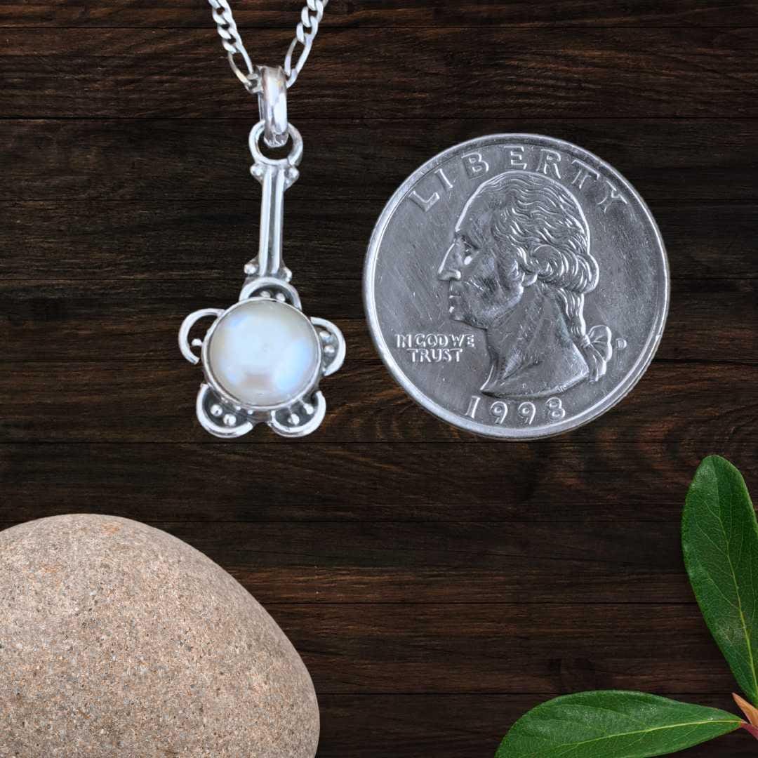an image of a Flower Pearl and Sterling Silver Pendant next to a quarter
