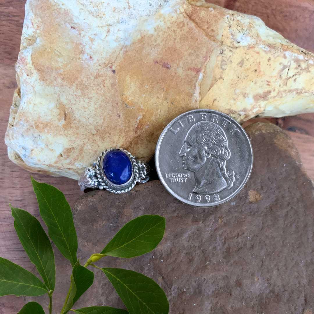 an image of an Oval Lapis Lazuli and Sterling Silver Ring With a heart on each side next to a quarter