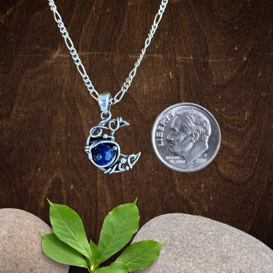an image of aDainty Sterling Silver Moon with Lapis Lazuli Pendant next to a dime